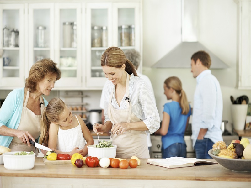 Mother And Grandmother Help Their Daughter To Make Salad